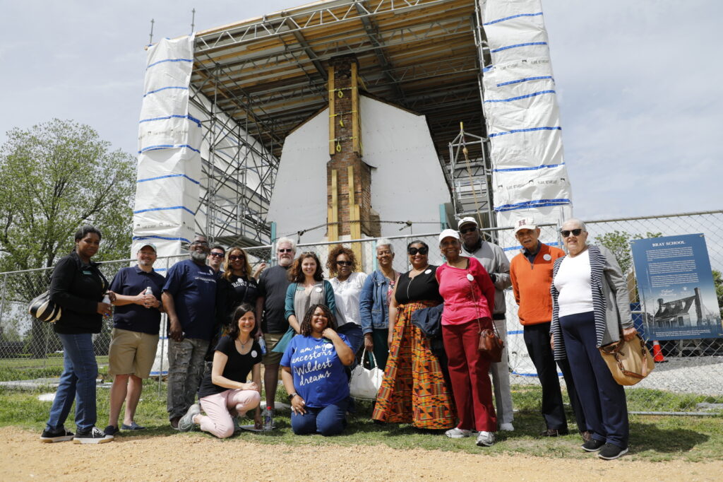 W&M Bray School Lab staff, Descendant Community members, and friends, standing outside the Williamsburg Bray School building, Descendants Week 2022.
